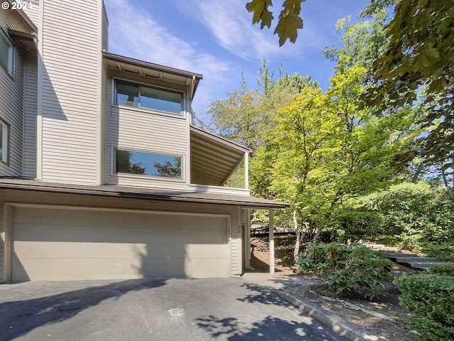 view of side of property with driveway and an attached garage