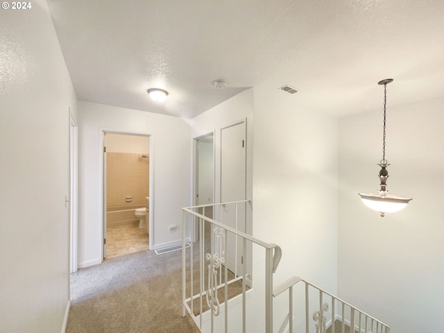 hallway featuring a textured ceiling and carpet