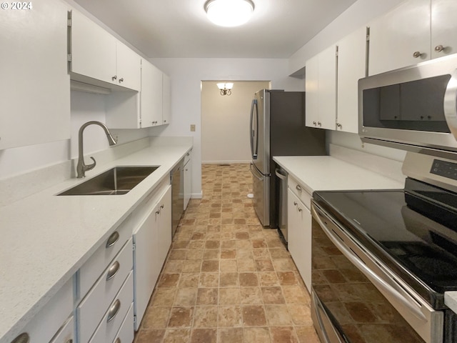 kitchen with stainless steel appliances, white cabinetry, and sink