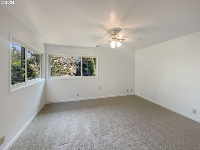 carpeted spare room featuring ceiling fan