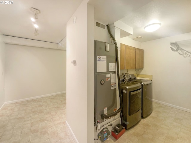 utility room featuring independent washer and dryer and heating unit