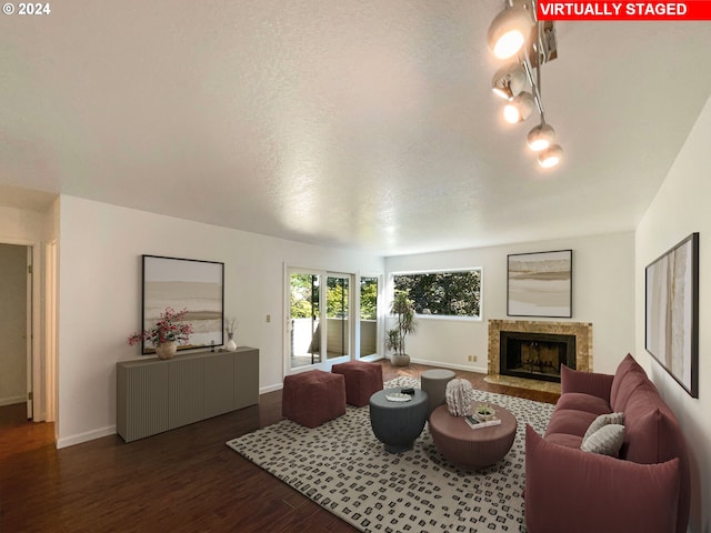 living room with a textured ceiling, a premium fireplace, and dark hardwood / wood-style floors