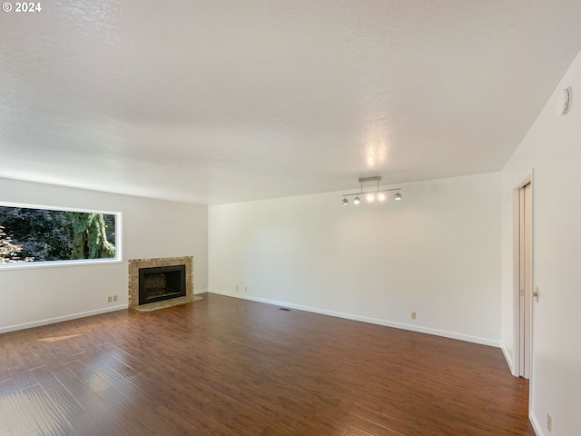 unfurnished living room featuring a textured ceiling and dark wood-type flooring