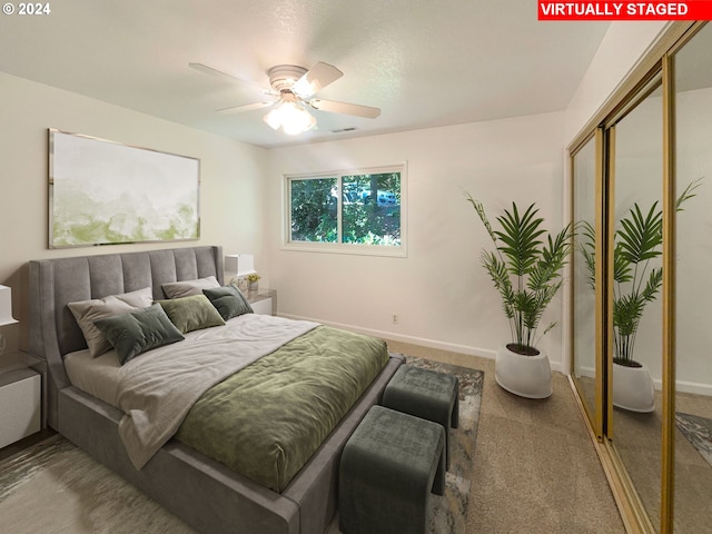 carpeted bedroom with ceiling fan and a closet