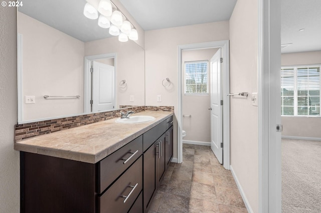 bathroom featuring vanity, backsplash, and toilet