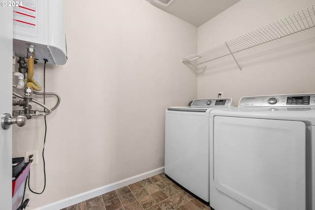 laundry area with water heater and washer and clothes dryer