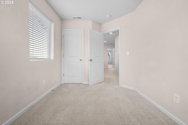 unfurnished bedroom featuring light carpet