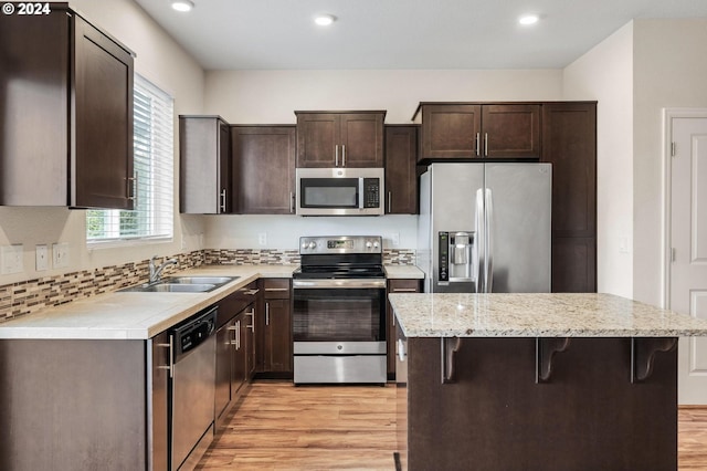 kitchen featuring sink, a breakfast bar, a center island, and appliances with stainless steel finishes