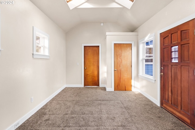 carpeted entrance foyer featuring vaulted ceiling with skylight and a textured ceiling