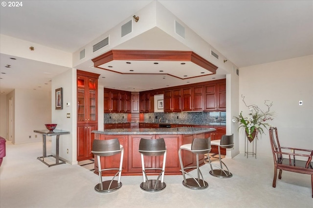 kitchen featuring backsplash, a center island, light colored carpet, and a breakfast bar