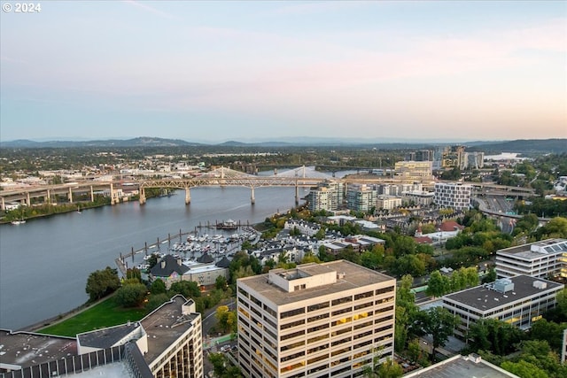 aerial view at dusk featuring a water view