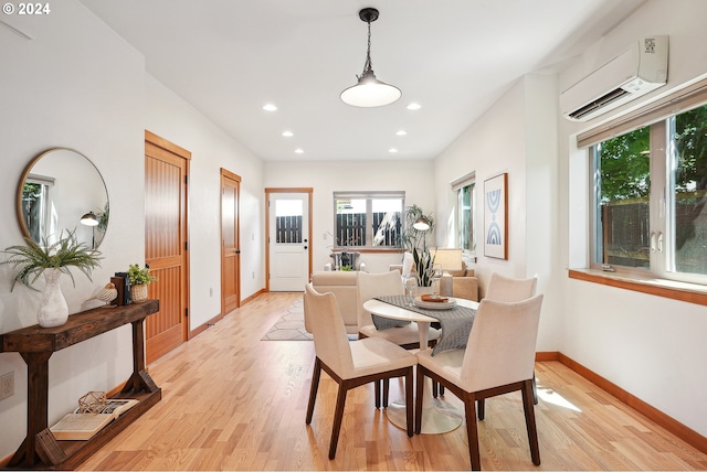 dining room featuring a wall unit AC and light hardwood / wood-style floors