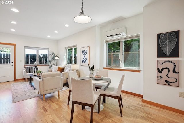 dining space featuring an AC wall unit and light wood-type flooring