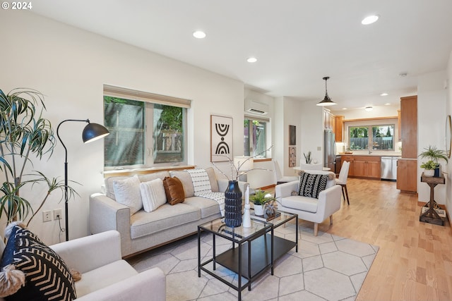 living room with light hardwood / wood-style flooring and an AC wall unit