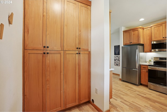 kitchen featuring stainless steel appliances and light hardwood / wood-style flooring