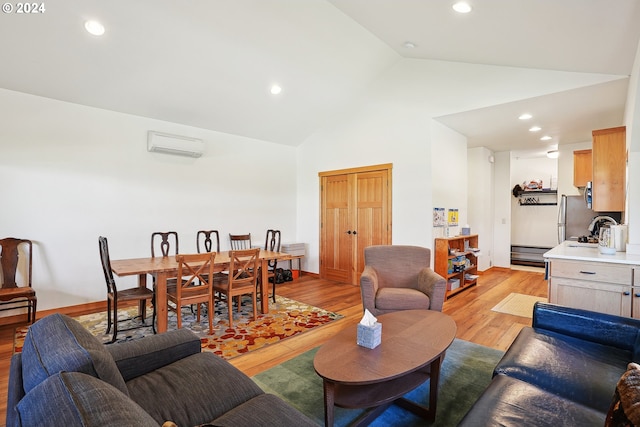 living room featuring light wood-type flooring, high vaulted ceiling, and a wall unit AC