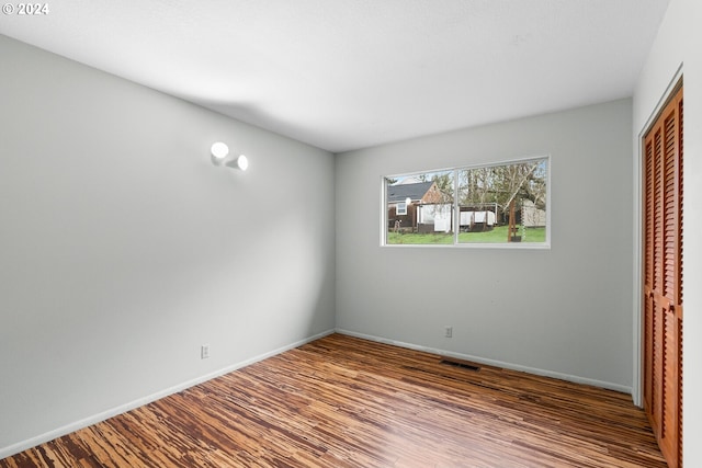 unfurnished bedroom featuring wood-type flooring and a closet