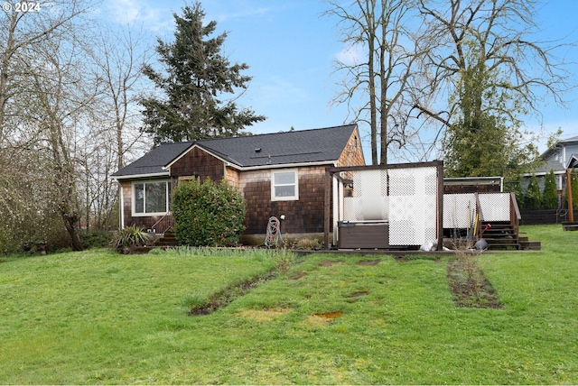 back of property featuring a deck and a lawn