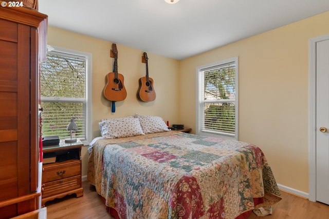 bedroom with light hardwood / wood-style floors and multiple windows