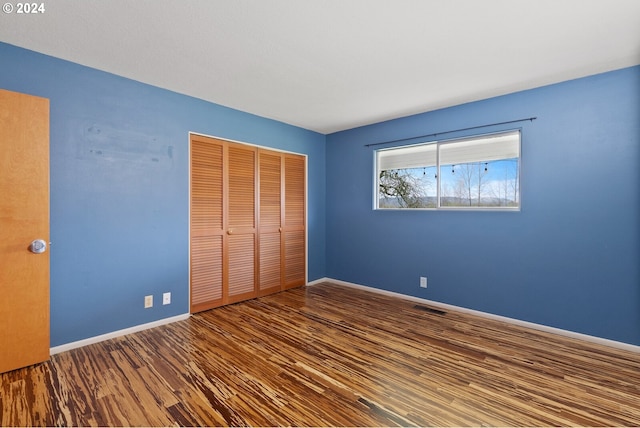 unfurnished bedroom with hardwood / wood-style floors and a closet