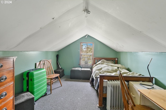 bedroom with radiator, lofted ceiling, and light colored carpet