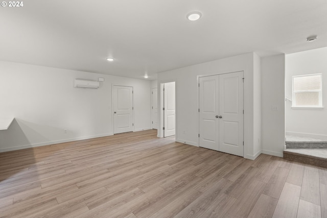 spare room with light hardwood / wood-style floors and a wall mounted air conditioner