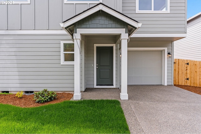 property entrance with a garage and a yard