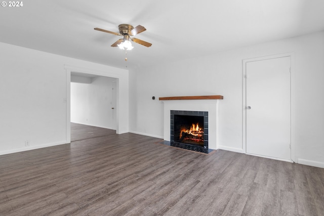 unfurnished living room featuring ceiling fan, a tiled fireplace, and hardwood / wood-style floors