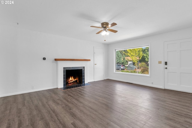 unfurnished living room featuring ceiling fan, a tiled fireplace, and hardwood / wood-style floors