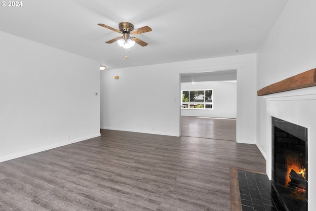 unfurnished living room featuring dark hardwood / wood-style flooring, a fireplace, and ceiling fan