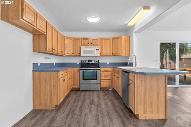 kitchen with appliances with stainless steel finishes, sink, kitchen peninsula, and dark hardwood / wood-style floors