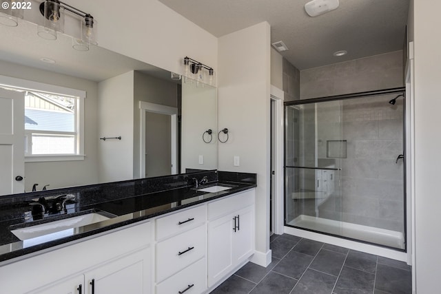 bathroom with double sink vanity, tile floors, and an enclosed shower