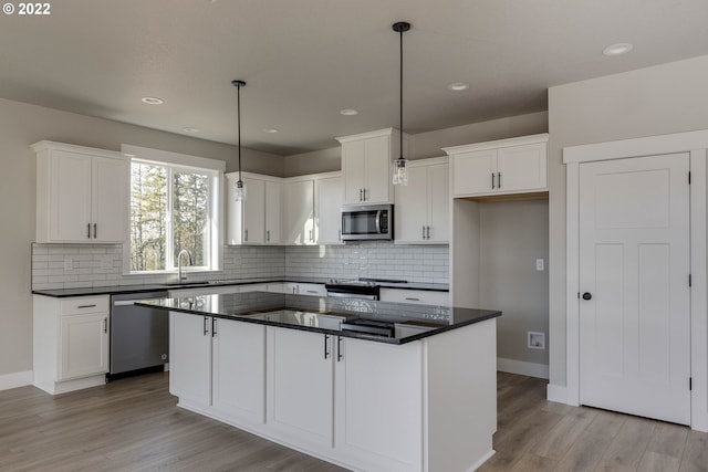 kitchen with white cabinets, pendant lighting, light hardwood / wood-style floors, and appliances with stainless steel finishes