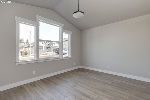 empty room featuring lofted ceiling and light wood-type flooring