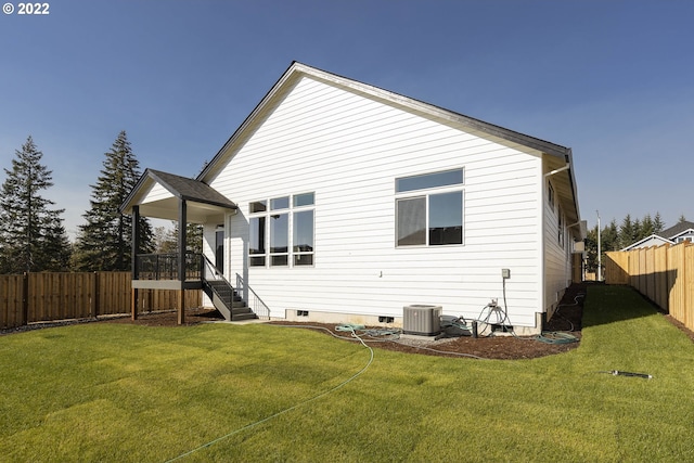 back of house featuring a yard and central AC