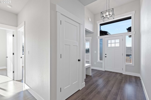 entrance foyer featuring dark wood-type flooring and a notable chandelier