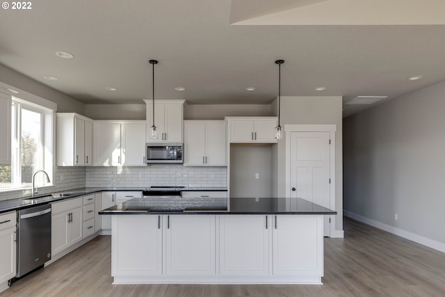 kitchen with pendant lighting, white cabinetry, appliances with stainless steel finishes, and a center island