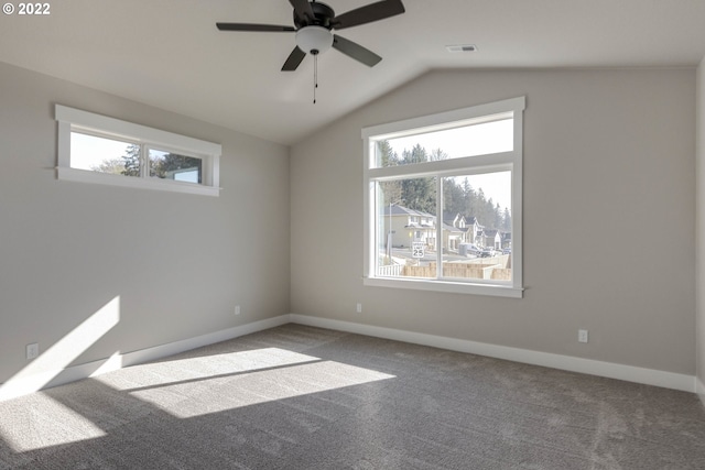 carpeted spare room with ceiling fan and vaulted ceiling