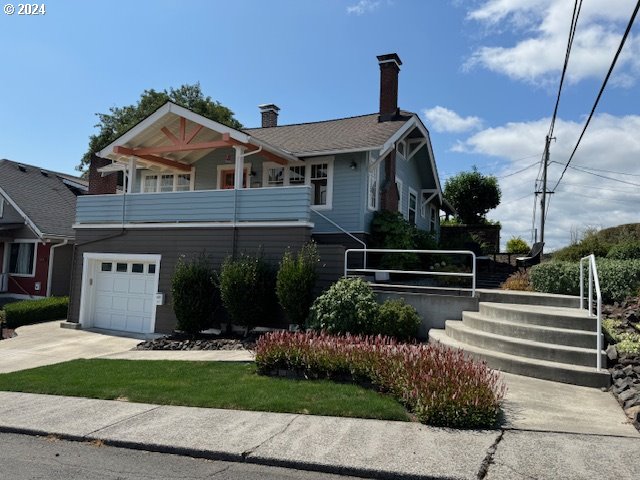 view of front of property featuring a balcony and a garage