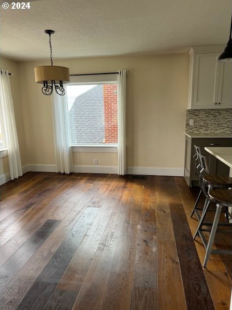 dining space with a textured ceiling, plenty of natural light, and wood-type flooring