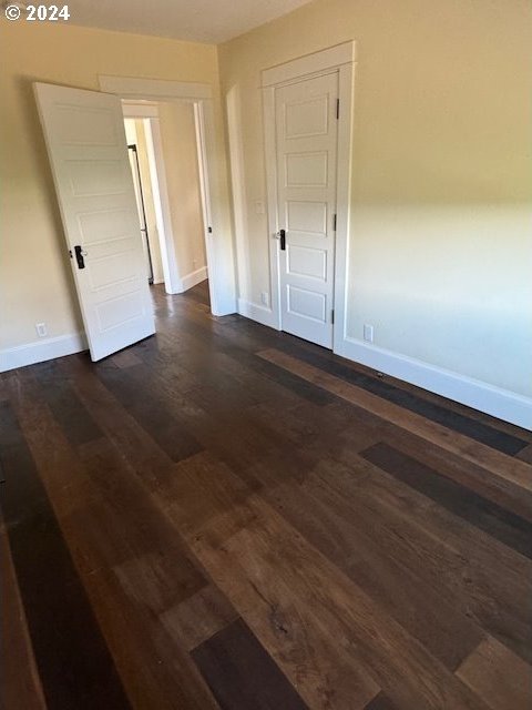 unfurnished bedroom with dark hardwood / wood-style flooring