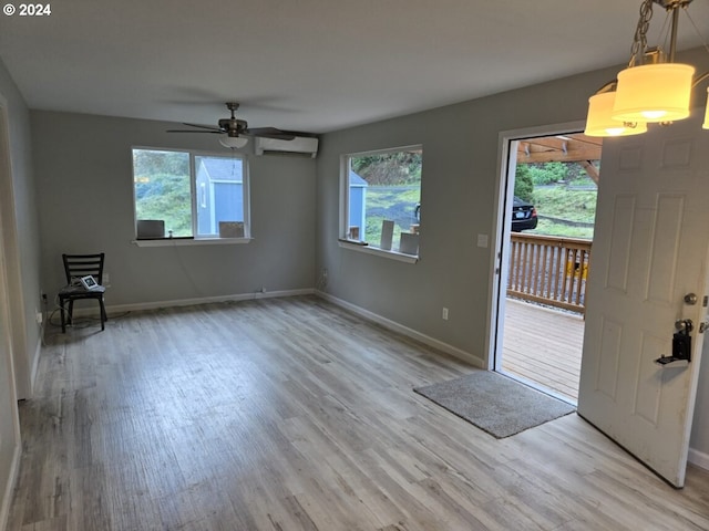 foyer featuring light hardwood / wood-style floors, a healthy amount of sunlight, and a wall unit AC