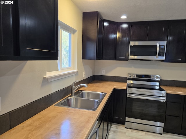 kitchen with sink, light hardwood / wood-style flooring, and stainless steel appliances