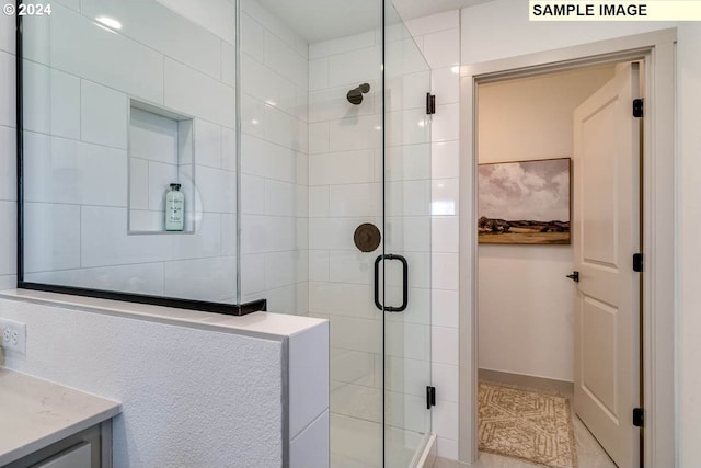 bathroom with tile patterned floors, vanity, and walk in shower