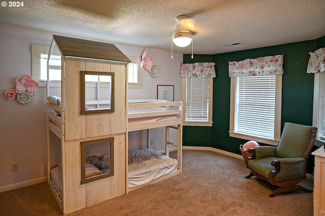 carpeted bedroom with ceiling fan, a textured ceiling, and multiple windows