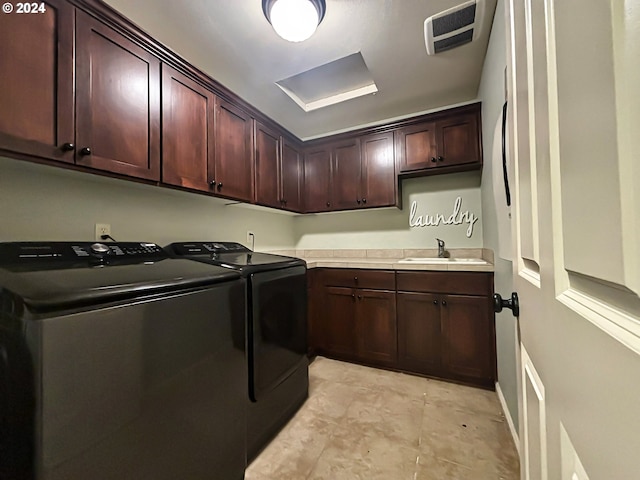 clothes washing area featuring cabinets, washing machine and dryer, and sink