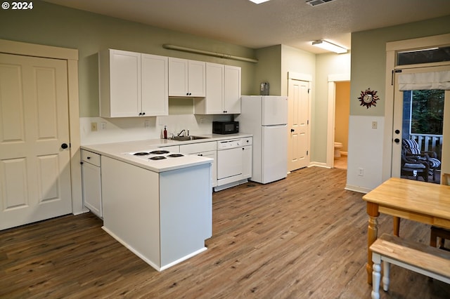 kitchen featuring sink, a textured ceiling, white appliances, white cabinets, and hardwood / wood-style flooring