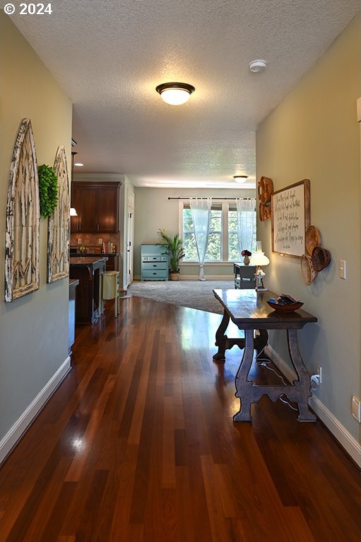 hallway featuring dark hardwood / wood-style flooring and a textured ceiling