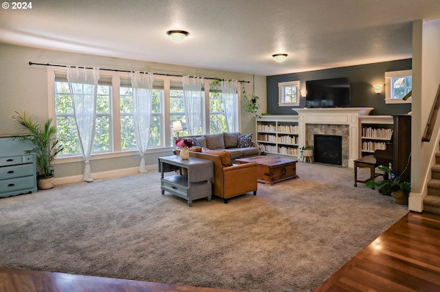 living room featuring a fireplace, a textured ceiling, and hardwood / wood-style flooring