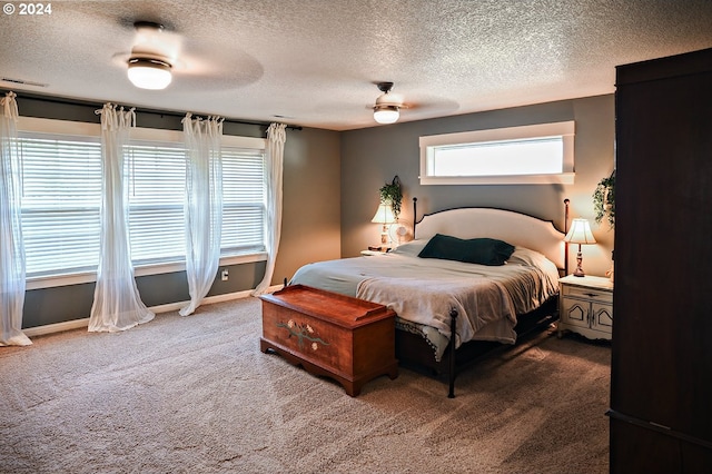 carpeted bedroom featuring a textured ceiling and ceiling fan